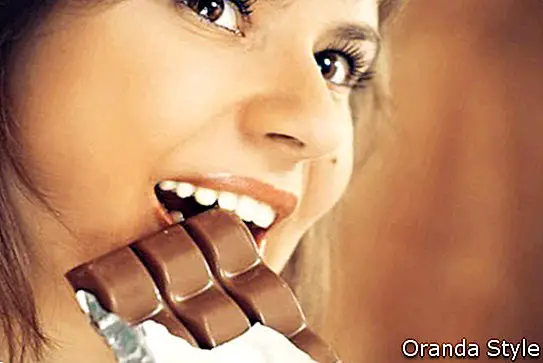 kvinne som biter en bar med sjokolade