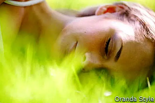 žena spí na zelené trávě