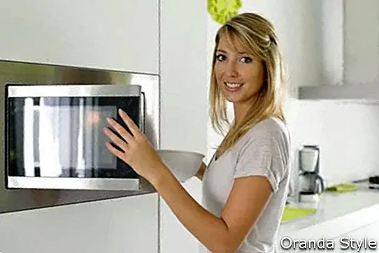 Mujer en casa usando horno microondas