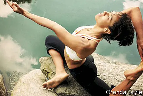 Mujer afroamericana en pose de yoga de paloma real