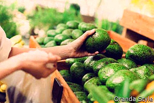 klant die avocado's in de supermarkt kiest