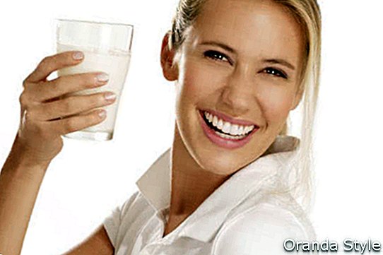 mladá žena pít mléko a usmíval se