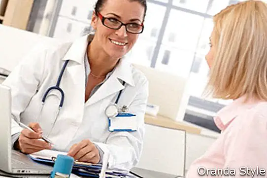 Feliz médico feminino morena no consultório médico com paciente