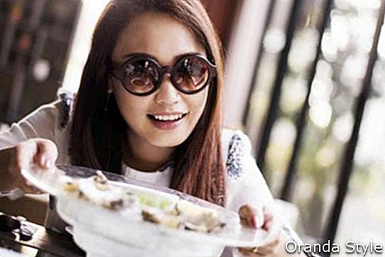 Iloiset nuoret naiset syövät raa'ita ostereita