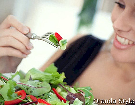 Mujer comiendo deliciosa ensalada verde