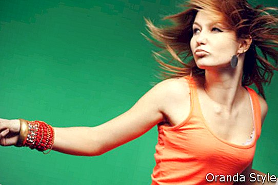 mujer bailando en camisa naranja