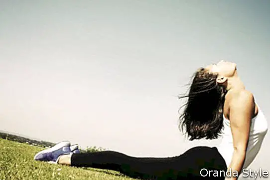 Ung kvinne som gjør en yogaposisjon og strekk