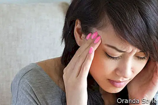 asiatische Frau mit Kopfschmerzen