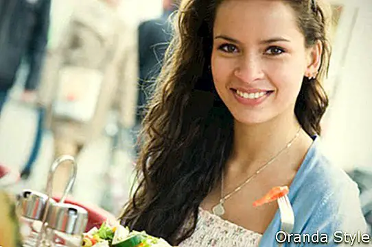 mujer comiendo ensalada saludable en restaurante
