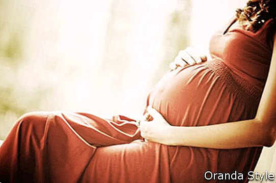 mujer embarazada tocando su vientre con las manos
