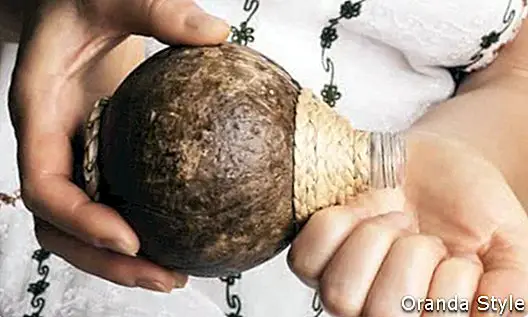 Frauenhände, die Kokosnussöl erhalten