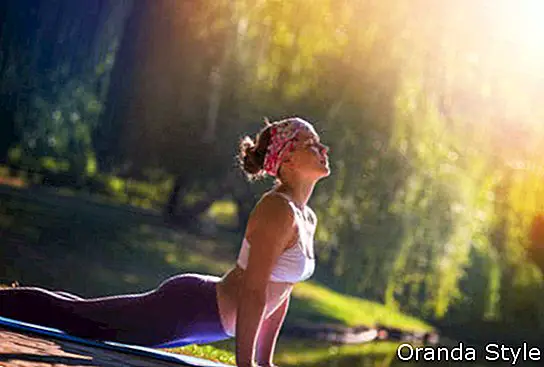 Junge Frau, die Yoga im Morgenpark tut