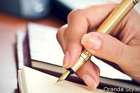 zelta pildspalva sievietes rokā