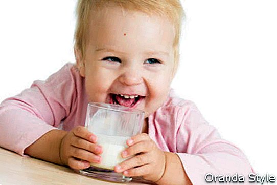 תינוק מחייך שותה יוגורט או קפיר