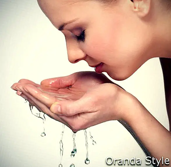 सुंदर महिला अपना चेहरा धो रही है