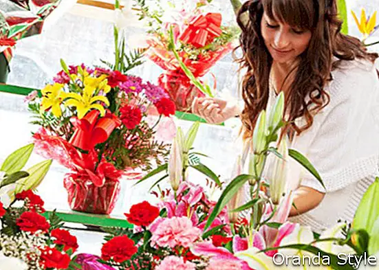 야외에서 신선한 꽃 시장 마구간에서 쇼핑하는 젊은 여자