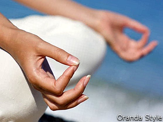 weibliche Hände während der Meditation am Strand