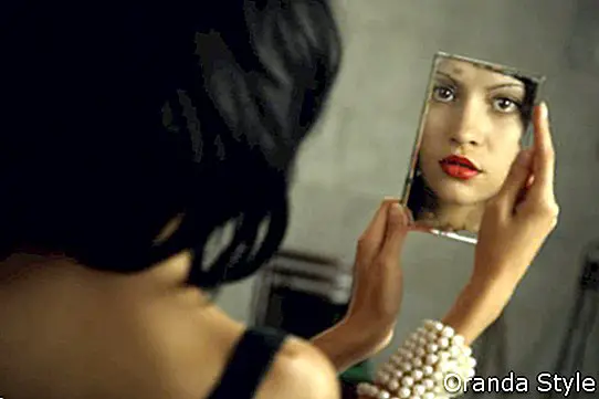 kvinna som ser sig själv i spegeln
