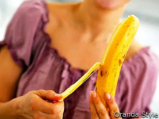 junge Frau, die Banane abzieht