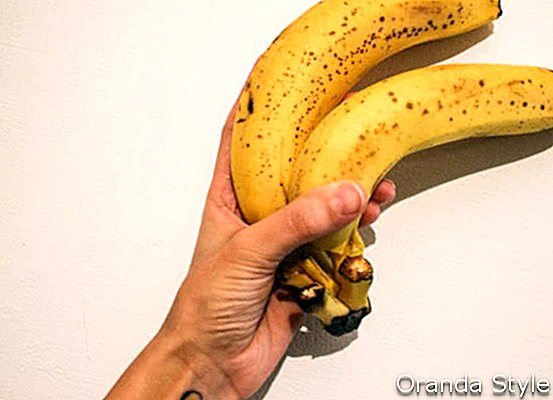 moteris, rankose laikanti du bananus
