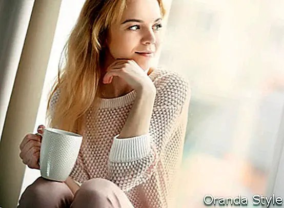 junge blonde Frau, die einen Tasse Kaffee genießt