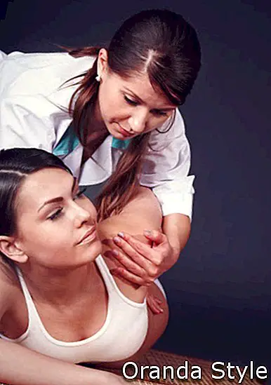 Терапеут пружа женској масажи истезања истезања