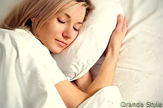 Nette kaukasische Frau, die auf dem Bett schläft