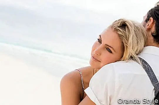 Затворено лице на млада жена, прегръщаща гаджето си на плажа