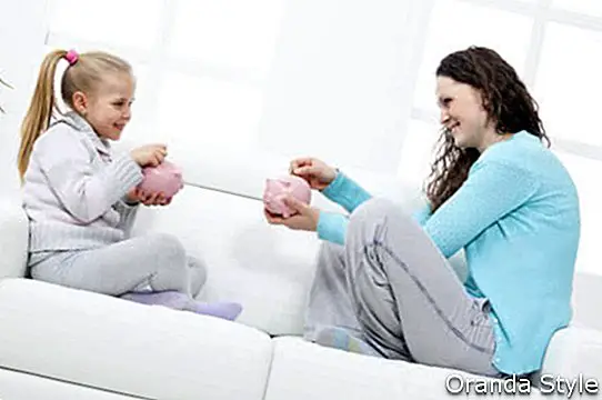 Māte un meita uz dīvāna uzzina par uzkrājumiem