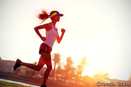 silhuet af en kvinde atlet løber ved solnedgang