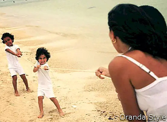madre jugando con sus hijos en la playa