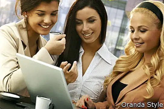 perniagaan wanita cantik yang berdiri di kafe luaran menggunakan komputer riba