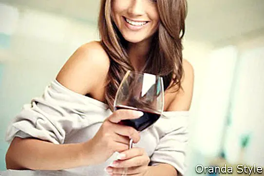 naine, kellel on klaas punast veini