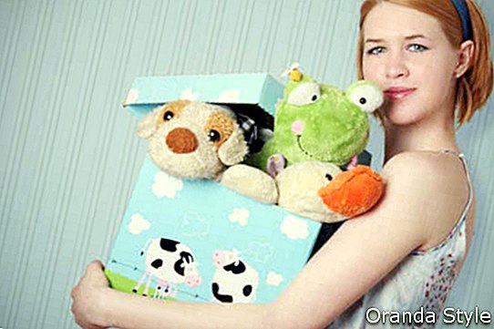 אישה מחזיקה קופסת צעצועים
