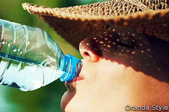 Trinkwasser der Frau im Sommersonnenlicht