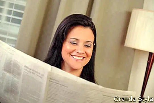 Frau liest Zeitung zu Hause