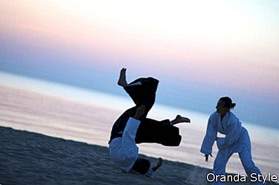 Aikido harjutamine päikeseloojangul rannas