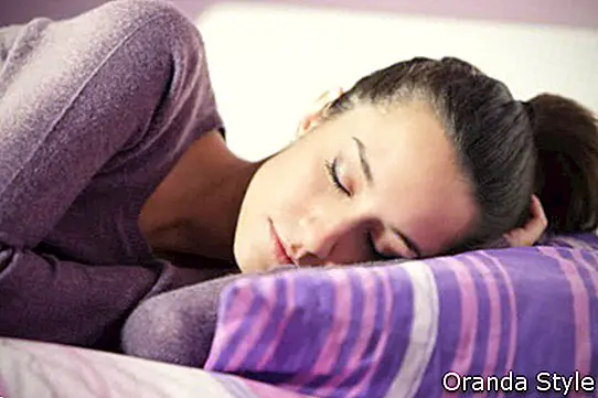 atraktivní mladá žena doma spí v posteli