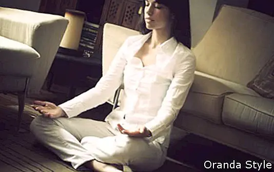 kvinna mediterar i vardagsrummet