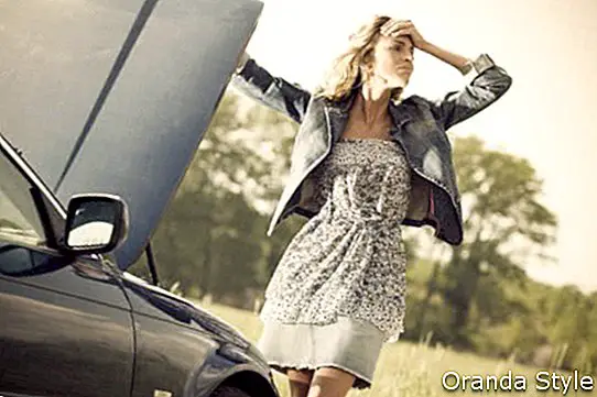 Mujer joven preocupada con su auto roto