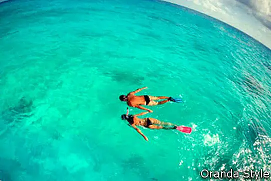 par roniti snorkeling s papučicama prikazuju na medenom odmoru