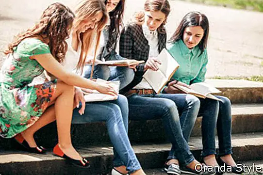 Група студенти, седнали с книги на улицата