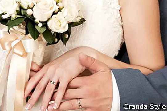 Las manos de la novia y el novio con anillos de boda