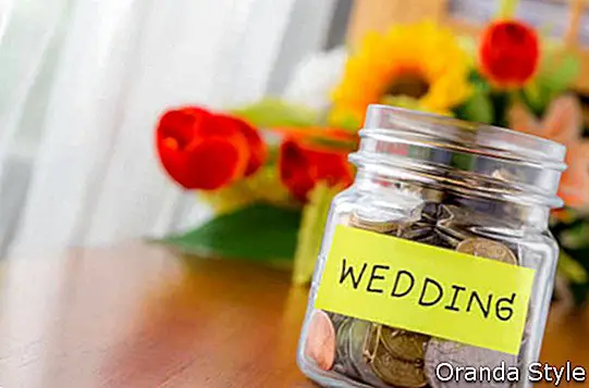 monetos-in-a-money-stiklainis-su-vestuvių etiketė ant stiklainio, gėlės-fone