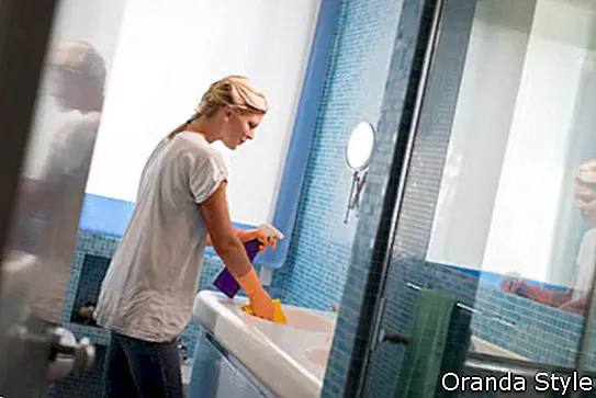 naine teeb kodus vannitoas koristustöid