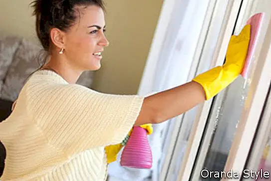 אישה מנקה חלונות בבית