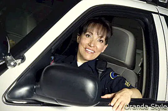 Petugas polisi wanita duduk di mobil patroli