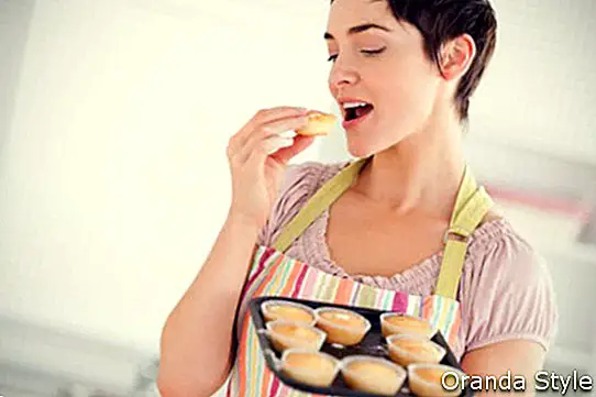 若い女性が自宅でクッキーを焼く