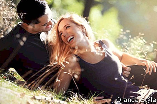 jauns pāris smaida viens otram romantiska randiņa laikā mežā
