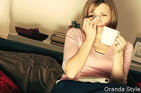 אישה מרגיעה עם כוס קפה צופה בטלוויזיה